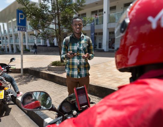 Man with a mobile phone talking with a person on a bike