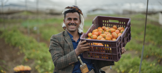 Man smiling with basket of fruit